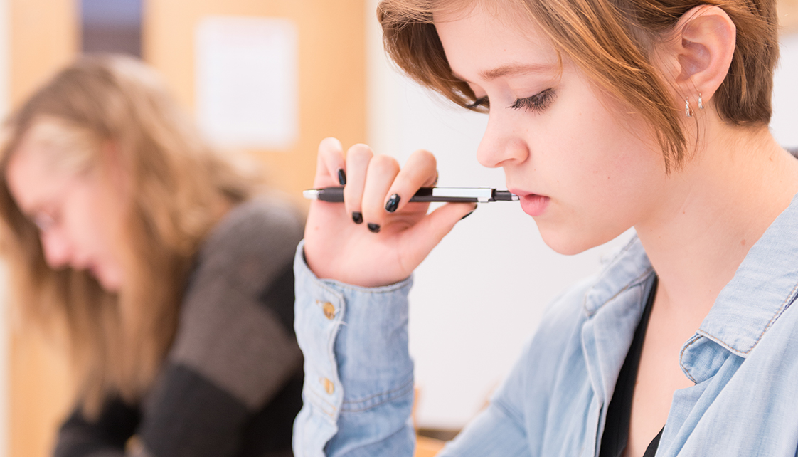 Female student with pen in mouth