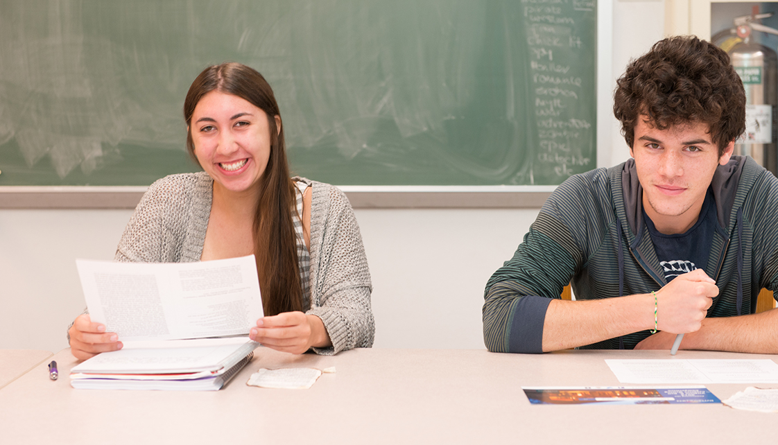 Male and female student smiling in class