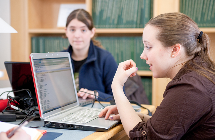A student uses library resources while writing a paper.